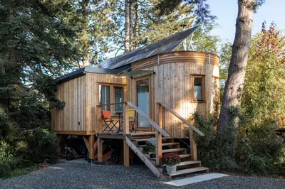 a wooden tiny house with a porch and stairs at Logis Freyja in Landschlacht Gemeinde Münsterlingen