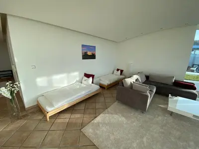 a living room with a bed and a couch at Exklusive Mini-Villa mit viel Platz in Herisau