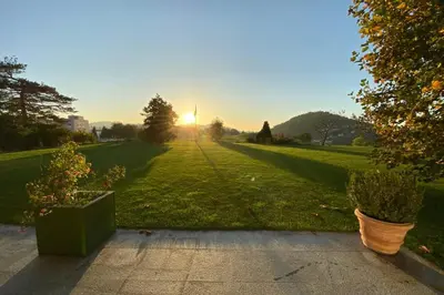 a park with the sun setting in the distance at Exklusive Mini-Villa mit viel Platz in Herisau