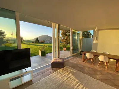 a living room with a television and a table and chairs at Exklusive Mini-Villa mit viel Platz in Herisau