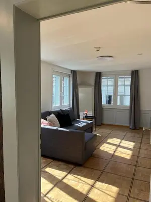 a living room with a black couch in a living room at Hotel Untertor by Maier - Self-Check-in in Altstätten