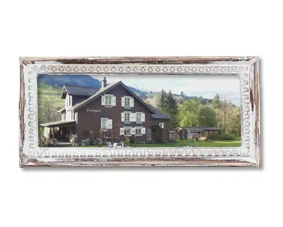 a large brown house with mountains in the background at Studio Chic mit Whirlpool in Wildhaus
