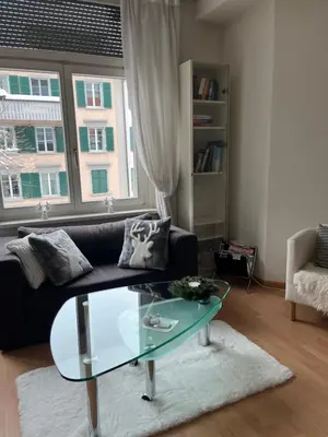a living room with a couch and a glass table at over-night City-Flat in St. Gallen