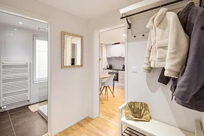 a white bathroom with a mirror and a room at VISIMO Apartments Felsenstrasse St Gallen - Elegant heritage building in a quiet neighbourhood in St. Gallen