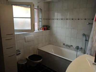 a bathroom with a tub and a toilet and a sink at B&B Im Bitzi in Zuzwil