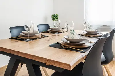 a wooden table with plates and wine glasses on it at SOHO 11 !Gratis Parken, Free Parking! in Kreuzlingen