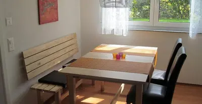 a dining room table and bench with a table and chairs at Ferienwohnung am Bach in Kreuzlingen
