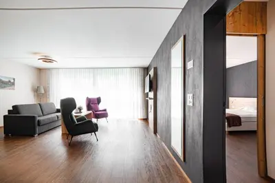 a living room with a couch a chair and a bed at Wohntel - wohnen wie im Hotel in Sevelen