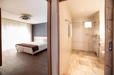 a bedroom with a bed and a bathroom with a shower at Wohntel - wohnen wie im Hotel in Sevelen