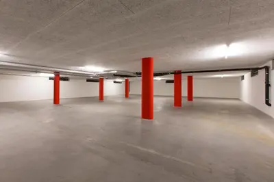 an empty parking garage with red poles in it at Wohntel - wohnen wie im Hotel in Sevelen