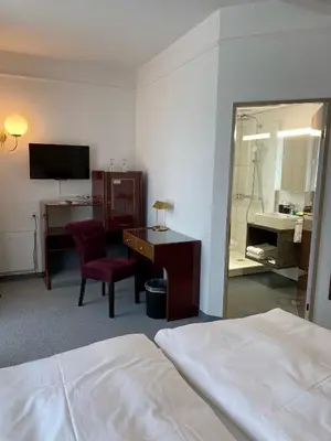 a hotel room with a bed and a desk and a mirror at Boutique City Hotel Gallo in St. Gallen