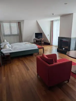 a bedroom with a bed and a red couch at Bad Horn - Hotel & Spa in Horn