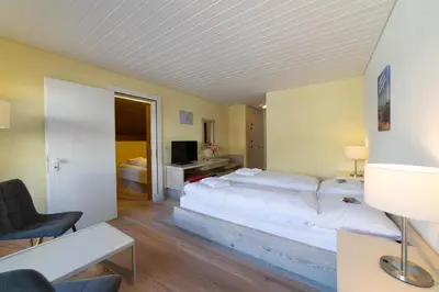 a bedroom with a large bed with white pillows at Hotel Säntis Lodge in Unterwasser