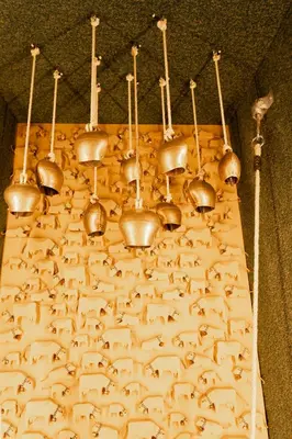 a bunch of copper bells hanging from a wall at Hotel Säntis Lodge in Unterwasser
