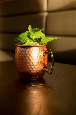 a copper cup with a plant in it on a table at Hotel Walhalla in St. Gallen