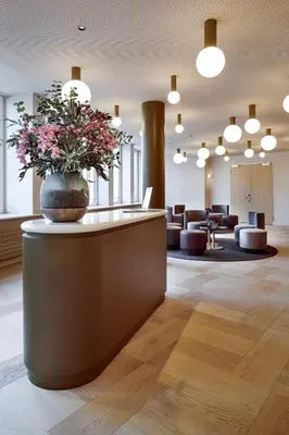 a lobby with a vase of flowers on a counter at Hotel Walhalla in St. Gallen
