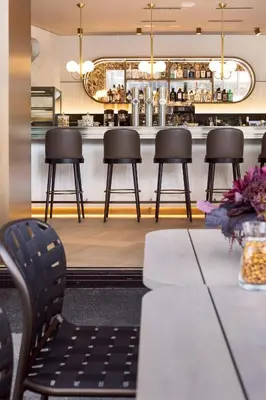 a table and chairs in a restaurant with a bar at Hotel Walhalla in St. Gallen