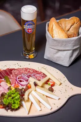 a plate of food and a glass of beer and bread at Hotel Walhalla in St. Gallen