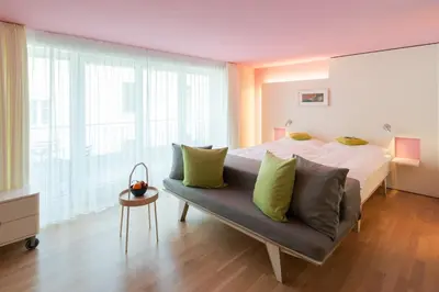 a bedroom with a large bed and a couch at Hotel Dom, zentral - herzlich - sozial engagiert in St. Gallen
