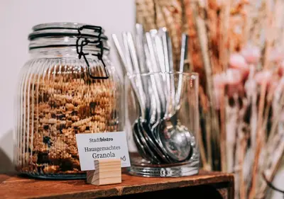 a couple of glass jars on a shelf with a sign at Hotel Dom, zentral - herzlich - sozial engagiert in St. Gallen