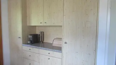 a kitchen with wooden cabinets and a coffee maker at Billenberghof in St. Gallen