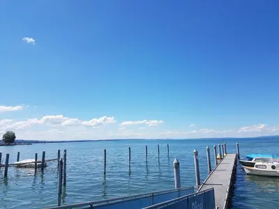 a dock with a boat in the water at Rome Apartment in Rheineck