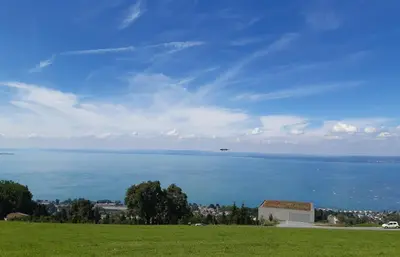 an airplane flying over the water in a field at Rome Apartment in Rheineck