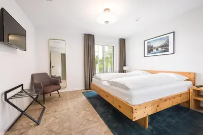 a bedroom with a large bed and a chair at Klein Rigi in Schönenberg