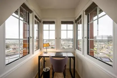 an office with windows and a desk with a lamp at Klein Rigi in Schönenberg