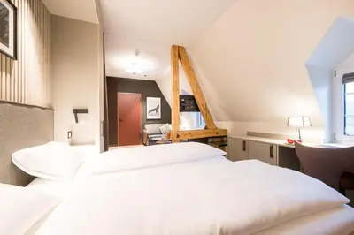 a bedroom with a large white bed and a desk at Klein Rigi in Schönenberg