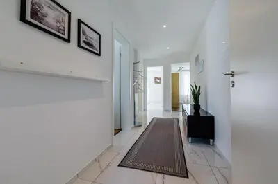 a hallway with white walls and a door with a rug at Aparthotel Mama Home Arbon in Arbon