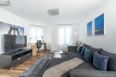 a living room with a couch and a flat screen tv at Aparthotel Mama Home Arbon in Arbon