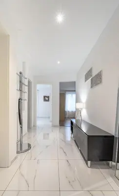 a living room with a large white room with a table at Aparthotel Mama Home Arbon in Arbon
