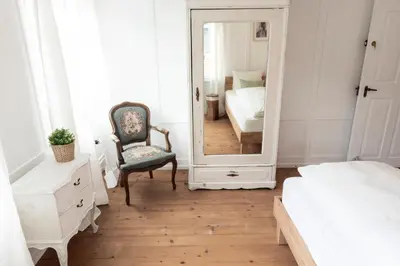 a bedroom with a mirror and a chair and a bed at Villa Donkey Ferienwohnung 113 in Degersheim