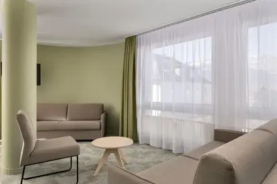 a living room with a couch and a window at flexymotel Buchs in Buchs
