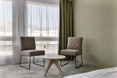 two chairs and a table in a hotel room at flexymotel Buchs in Buchs