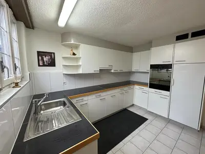a kitchen with white cabinets and a sink at Lakeside Apartments Rorschach - easy self check-in in Rorschach
