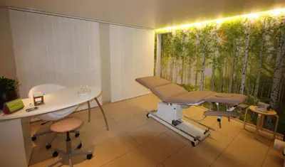 a hospital room with a table and chairs and a window at Hotel Frohe Aussicht in Weissbad