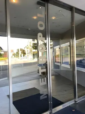 a glass door of a building with a reflection in it at Hotel Metropol in Widnau