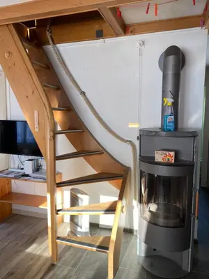 a spiral staircase in a tiny house with a stove at Appenzellerland - Ferienhaus 