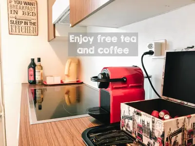 an empty free tea and coffee shop with a red coffee machine at CityLodge St Gallen - 2 min to Marktplatz in St. Gallen