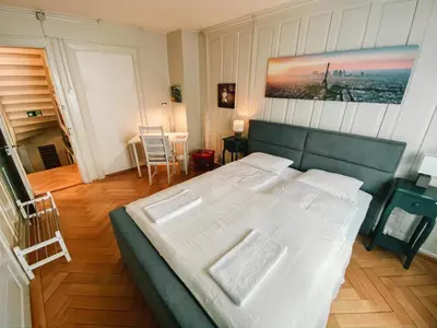 a bedroom with a large bed with white sheets at CityLodge St Gallen - 2 min to Marktplatz in St. Gallen