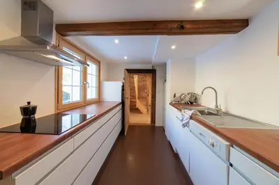 a kitchen with white cabinets and a wooden counter top at Sigerst in Wildhaus