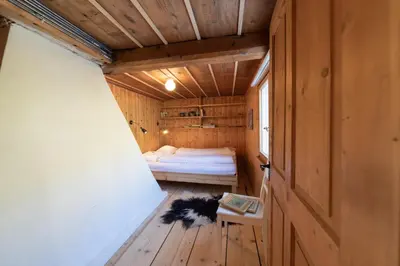 a small bedroom with a bed and a dog laying on the floor at Sigerst in Wildhaus