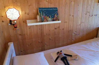 a bedroom with a bed with a book and a lamp at Sigerst in Wildhaus