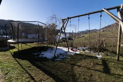 an empty swing set in a yard with a hill at Sigerst in Wildhaus