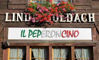 a sign on the side of a building with flowers at Hotel Linde Goldach in Goldach
