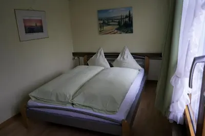 a bedroom with a bed with white sheets and pillows at Hotel Linde Goldach in Goldach