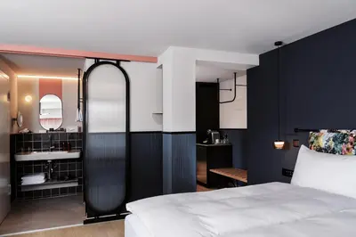 a bedroom with a white bed and a black wall at Sorell Boutique-Hotel City Weissenstein St Gallen in St. Gallen