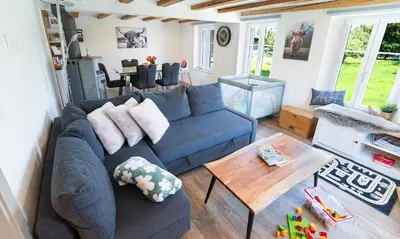 a living room with a blue couch and a table at Ferienhaus Kluser in Oberriet